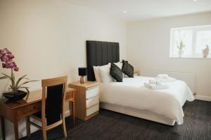 - une chambre avec un grand lit blanc, un bureau et une fenêtre dans l'établissement Seaview and Poolside Apt 18 central location, à Newquay