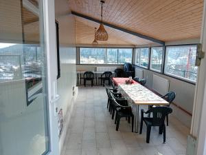 a dining room with tables and chairs and windows at Vila Alegria in Buşteni