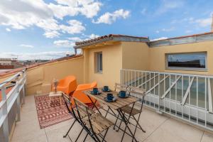 a balcony with a table and chairs on a roof at Le Panorama - Rooftop & Climatisation in Montpellier