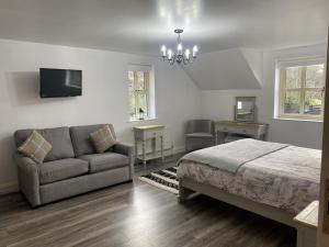 a bedroom with a bed and a couch and a tv at Mountain View Retreat in Rostrevor With hot Tub in Newry