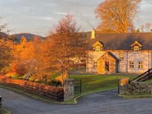 a large stone house with a driveway at Mountain View Retreat in Rostrevor With hot Tub in Newry