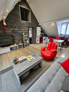 - un salon avec un canapé et un fauteuil rouge dans l'établissement Gîte Vallée de Munster 3 étoiles chez Flavie & Ludo, à Muhlbach-sur-Munster