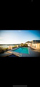 une photo d'une piscine avec l'océan en arrière-plan dans l'établissement Seaview and Poolside Apt 18 central location, à Newquay