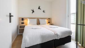 ein Schlafzimmer mit einem großen Bett mit Vögeln an der Wand in der Unterkunft Molecaten Park Waterdunen in Breskens
