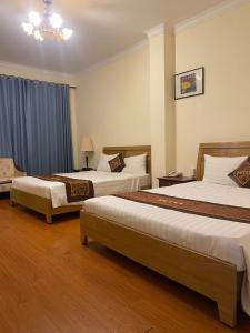 a hotel room with two beds and a chandelier at Ngọc Lan Hotel in Ho Chi Minh City +73 photos