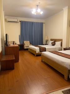 a hotel room with two beds and a couch at Ngọc Lan Hotel in Ho Chi Minh City