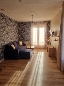a living room with a couch and a table at Maison à la campagne 2 à 4 personnes in Anzème