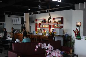 a bar in a restaurant with people sitting at a counter at FountainBlue Hotel and Banquet Hall in Locsin