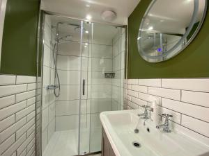 a bathroom with a shower and a sink and a mirror at Goodwin House in Keswick +30 photos
