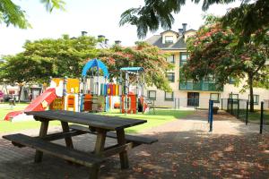 a picnic table in a park with a playground at Luxury Singular Apartments Green in Santiago de Compostela