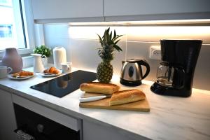 una encimera de cocina con pan y una piña en una tabla de cortar en Studio Paris, en Ivry-sur-Seine