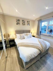 a bedroom with a large bed and a window at Stunning 5 Bedroom House in London - Sleeps up to 10 guests - Business - Contractors - Families - Leisure - WiFi - Parking - Garden in Grove Park