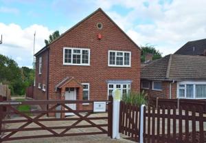 a brick house with a wooden fence in front of it at Stunning 5 Bedroom House in London - Sleeps up to 10 guests - Business - Contractors - Families - Leisure - WiFi - Parking - Garden in Grove Park +46 photos