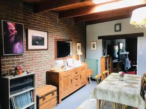 a living room with a table and a brick wall at Family home in Thon, garden and terrace 100 m² in Namêche
