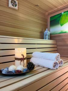a candle and towels on a shelf in a sauna at Hotel Europa in San Martino di Castrozza