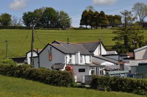 a group of houses in a field with trees at Pyne Arms in Barnstaple
