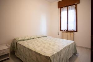 a bedroom with a bed and a window at Dimora Giannino e Mirella in Pellestrina