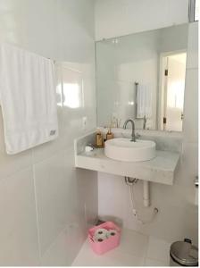 a white bathroom with a sink and a mirror at Ap 3 Ouro Pret com piscina aquecimento solar e churrasqueira in Ouro Preto +33 photos