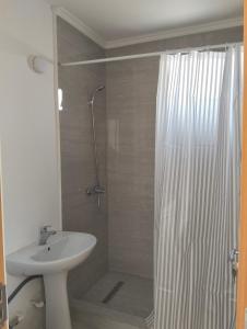 a bathroom with a sink and a shower with a shower curtain at Apartament BIS in Buzau