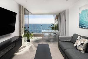 a living room with a couch and a view of the ocean at Perla Negra - Apartment with Private Beach Access in Benalmádena