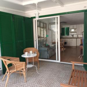 ein Wohnzimmer mit grünen Wänden sowie einem Tisch und Stühlen in der Unterkunft Sweet Life in Costa Del Silencio