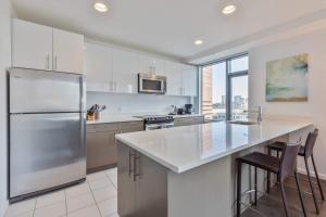 a kitchen with a stainless steel refrigerator and a counter at Luxury Apt Near Kendall Sq in Cambridge +14 photos