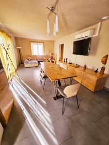 ル・トールにあるMaison au bord de l'eauの木製テーブルと椅子付きの広いリビングルーム