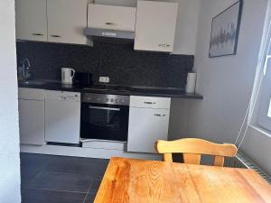 a kitchen with white appliances and a wooden table at Haus mit Terrasse&Garten in Ilsede +9 photos