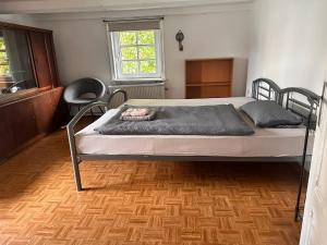 a bed in a room with a wooden floor at Haus mit Terrasse&Garten in Ilsede