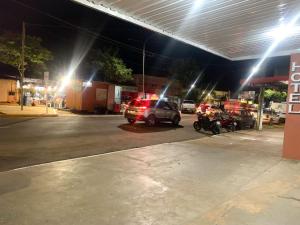un groupe de voitures garées dans une station-service la nuit dans l'établissement Hotel Avenida, à Ribas do Rio Pardo