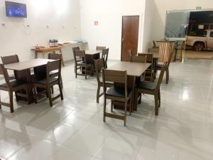 une salle à manger avec des tables et des chaises en bois dans l'établissement Hotel Avenida, à Ribas do Rio Pardo 9 autres photos
