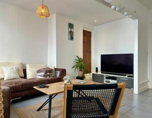 una sala de estar con un sofá y una mesa en Nid douillet pour 2 au Puy, en Le Puy en Velay