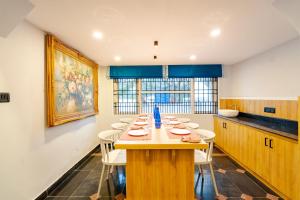 a dining room with a table and white chairs at MGM Whispering Nest Yelagiri in Yelagiri
