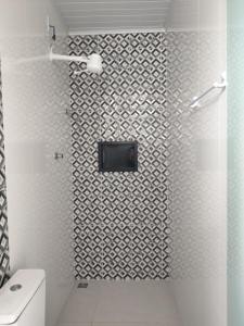 a bathroom with a shower with a tv on the wall at Recanto dos pássaros in Santa Cruz Cabrália +10 photos