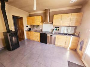 a large kitchen with wooden cabinets and a stove at Maison au bord de l'eau in Le Thor