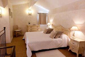 a hotel room with a bed, chair, and nightstand at Le Clos de la Glycine in Roussillon