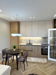 een keuken en eetkamer met een tafel en stoelen bij Downtown Shkodra Apartment in Shkodër