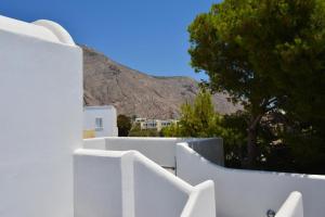 una recinzione bianca con una montagna sullo sfondo di Aegean Studios Perissa a Perissa