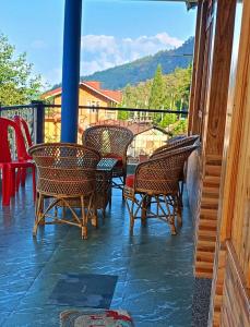 a patio with chairs and tables on a balcony at Kacey Homestay Ramdhura in Rangpo