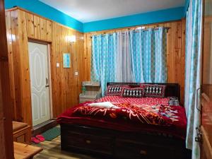 a bedroom with a red bed and a window at Kacey Homestay Ramdhura in Rangpo +12 photos