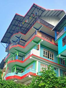 a multicolored building with a lot of balconies at Kacey Homestay Ramdhura in Rangpo