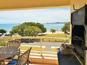 Un balcón con mesa y sillas y vista al mar. en Goldwater 7, en Gordonʼs Bay