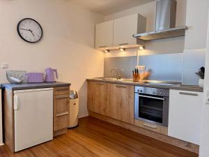 a kitchen with a sink and a clock on the wall at Schönes Appartment im Saarner Auenland in Mülheim an der Ruhr