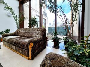 a couch sitting in a room with plants at Green Park Boutique Hotel in Focşani