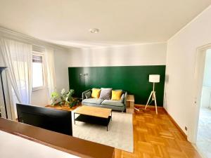 a living room with a couch and a green wall at Downtown Milan Chic Apartment - Quiet Retreat with Free WIFI & Air Conditioning in Milan +6 photos