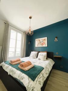 une chambre avec un lit avec deux serviettes dessus dans l'établissement Appartement sur cour quartier Olympiades, à Paris