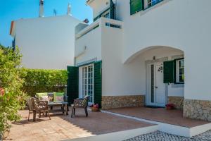 a patio with chairs and a table in front of a house at Villa Audiência 145 in Castro Marim