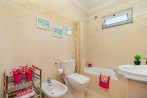a bathroom with a toilet and a sink and a tub at Villa Audiência 145 in Castro Marim +26 photos