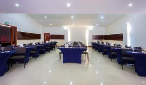 uma sala de jantar com mesas e cadeiras azuis em GHL Hotel Club el Puente em Girardot