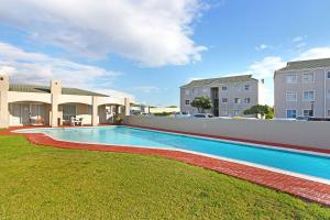 a swimming pool in the yard of a building at Big Bay Beach Club G6 by Host Agents in Cape Town
